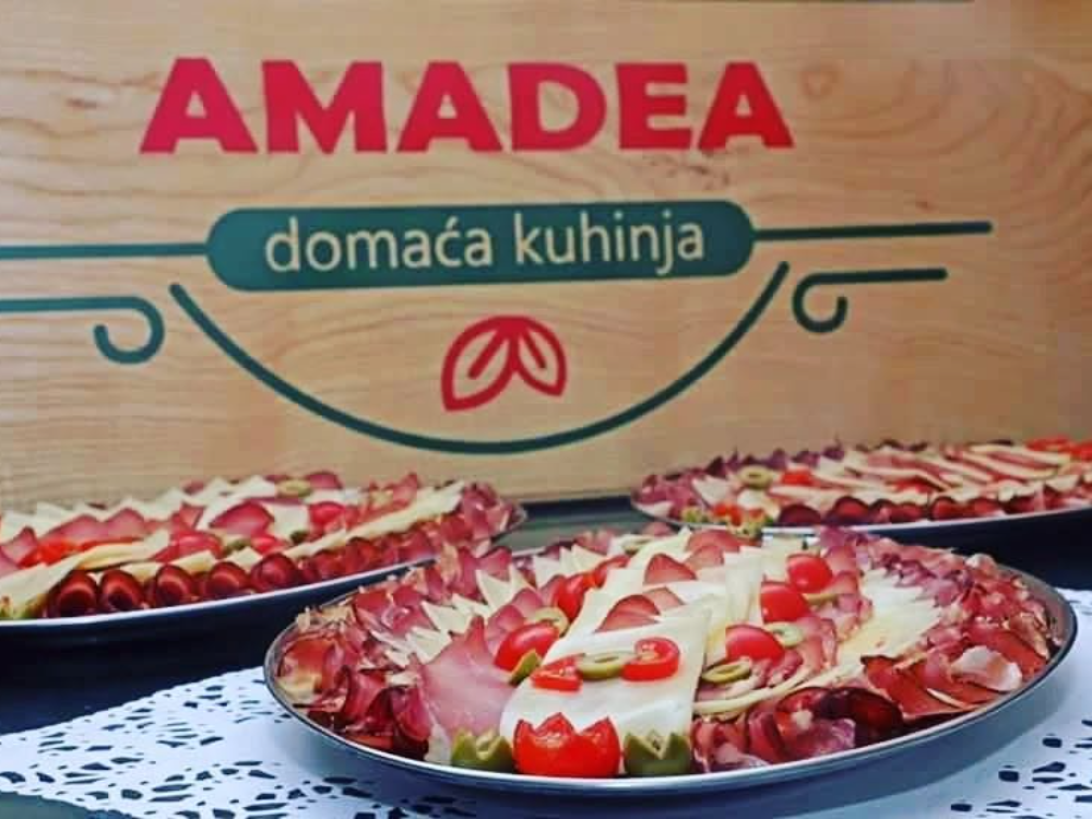 Tri platoa sa suhomesnatim proizvodima, sirom, maslinama i čeri paradajzom ispred Amadea table