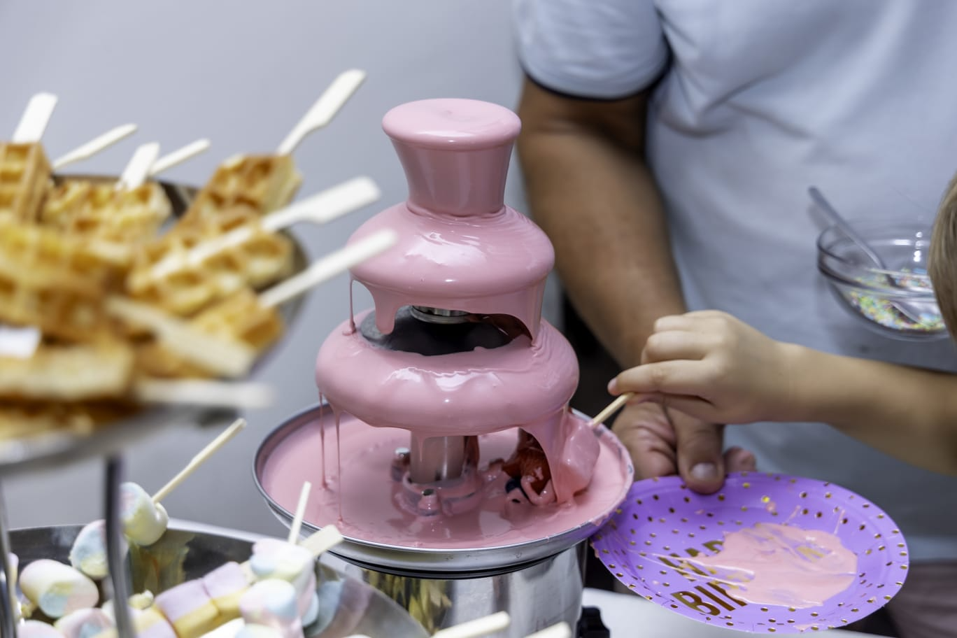 Roze čokoladna fontana sa vaflima i marshmallowima