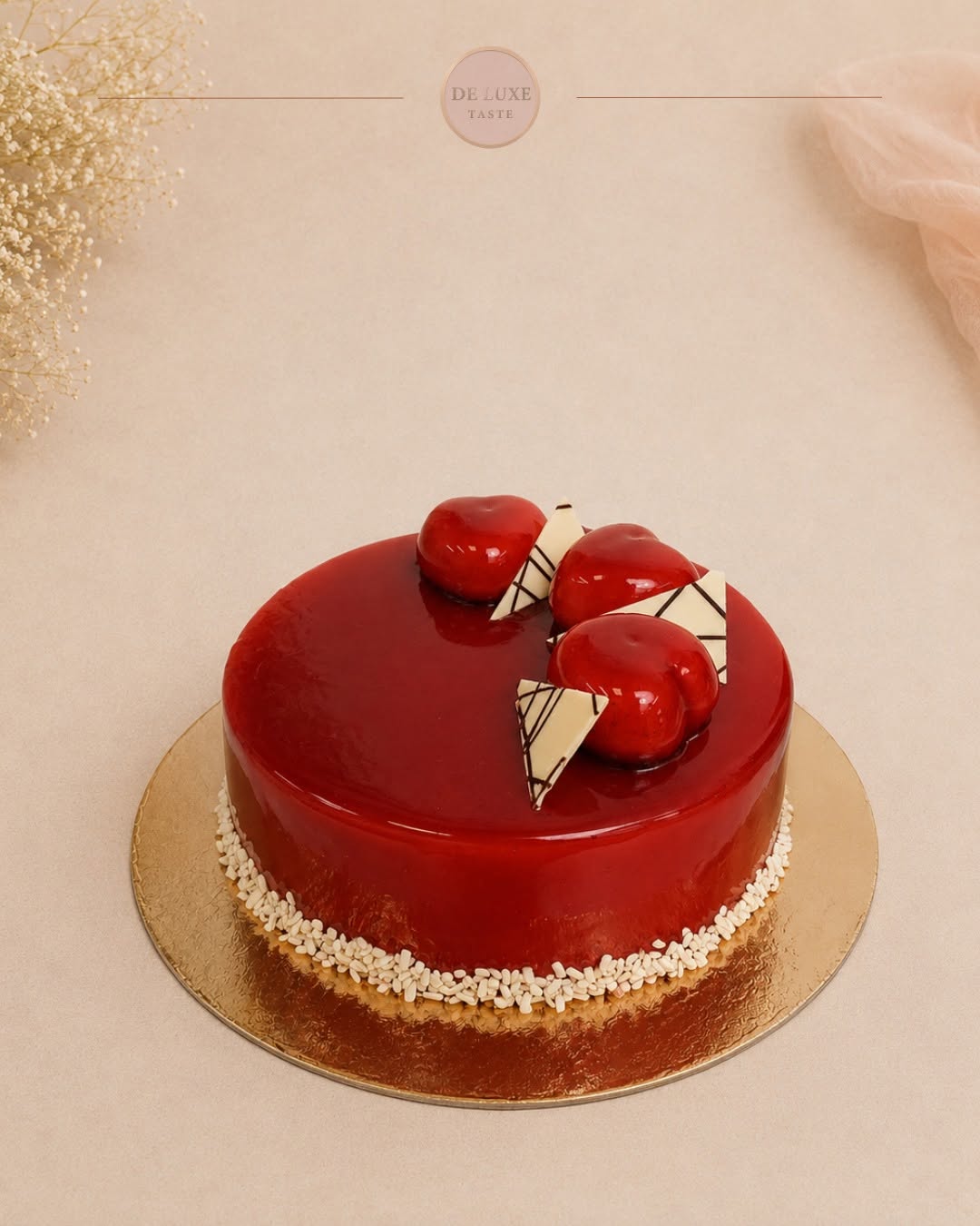 Torta sa crvenom glazurom, kupolama od voća i belim čokoladnim dekorom