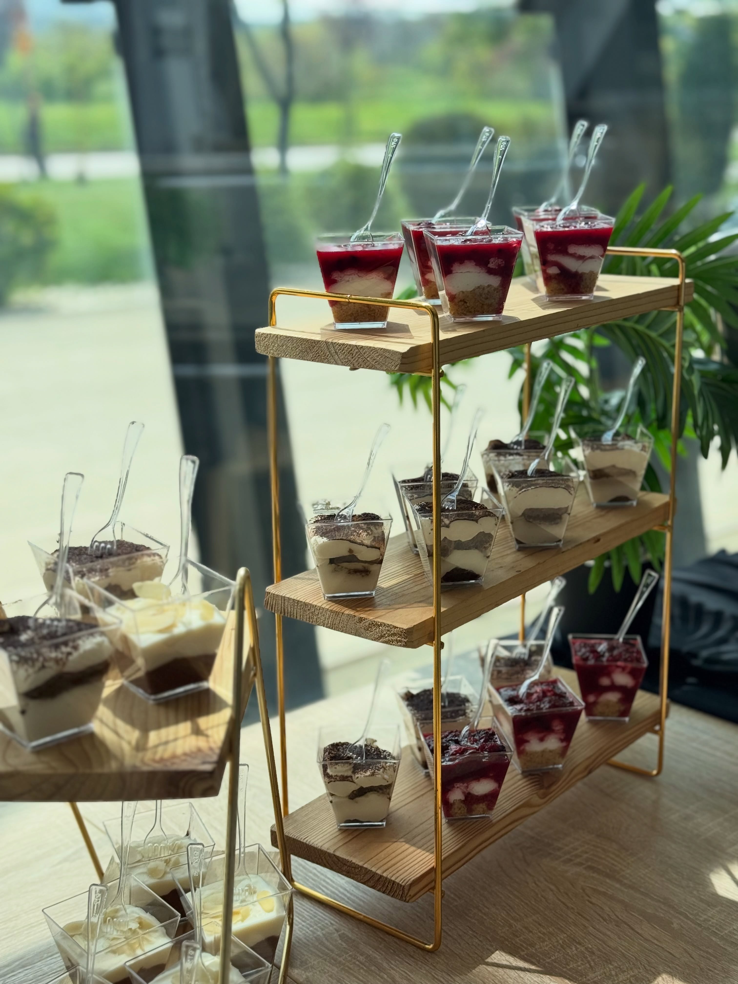 Etažer sa desertima u čašicama — tiramisu i cheesecake sa voćnim prelivom