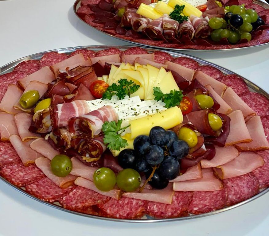 Ovalni poslužavnik sa suhomesnatim, sirom i grožđem