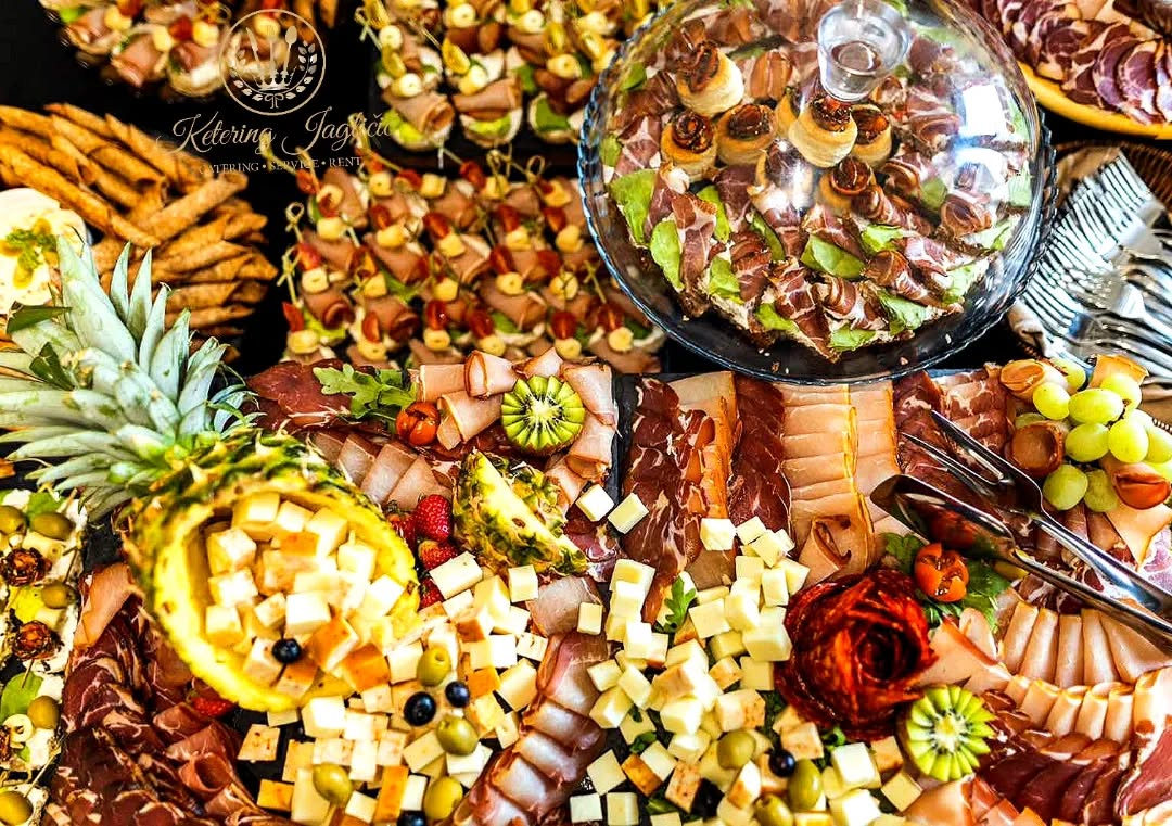 Plato sa pršutom, sirevima i ananasom, snimljen odozgo