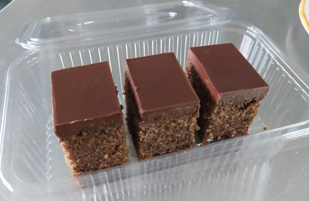 Tri kolača sa čokoladnom glazurom u prozirnoj kutiji za nošenje