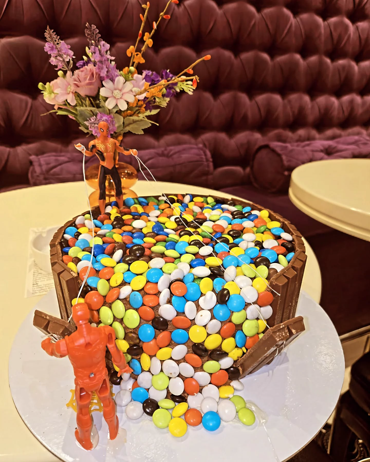 Rođendanska torta obložena čokoladicama i M&M bombonama, sa figurama superheroja