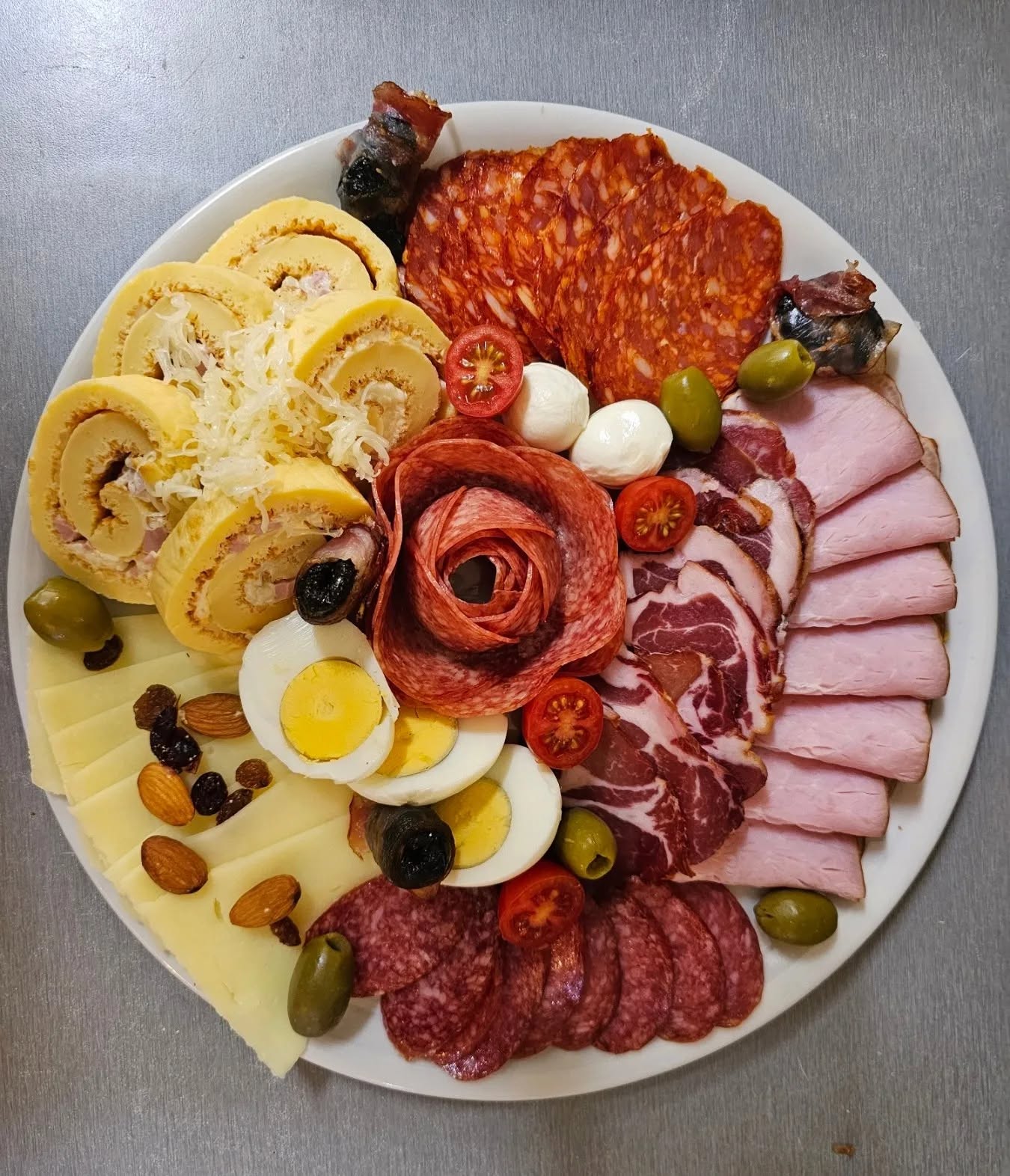 Veliki okrugli plato suhomesnatog i sireva sa rolatom, jajima, maslinama i rozetom od salame